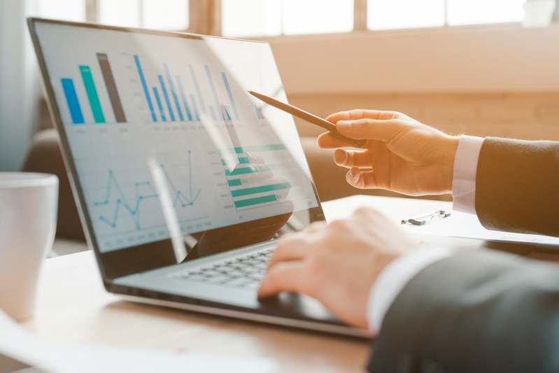 Author writing finance tips at a desk with notebook and calculator
